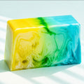 Handgefertigte Naturseife „Sunlight“ in Gelb, Türkis und Weiß mit marmorierter Optik. Frische Pflegeseife mit sommerlichem Design für die tägliche Hautpflege.